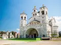 La Cattedrale della Resurrezione di Cristo a Podgorica, cosa vedere: imponente architettura ortodossa con torri campanarie e croci dorate sotto un cielo azzurro.
