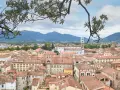Panoramica di Lucca con tetti rossi e montagne sullo sfondo. Perfetto per scoprire cosa vedere in un giorno.