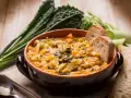 Zuppa di verdure e fagioli, un classico dei cibi tipici toscani, servita con pane rustico e contornata da cavolo nero.