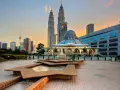 Le Petronas Towers dominano lo skyline di Kuala Lumpur, con una moschea moderna e fontane in primo piano. Un'ottima vista di cosa vedere a Kuala Lumpur al tramonto.