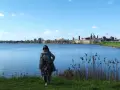 Donna con sciarpa e cappotto ammira il panorama di Mantova, un luogo incantevole da esplorare.