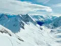Vette innevate e un cielo azzurro con nuvole soffici, un panorama mozzafiato per chi cerca cosa vedere a Courmayeur.