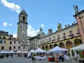 Mercato in piazza a Pontremoli, con la torre civica e il palazzo del Comune. Ecco cosa vedere a Pontremoli: un'atmosfera vivace.