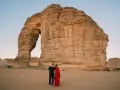 Coppia romantica davanti alla Roccia Elefante, una delle meraviglie naturali da vedere in Arabia Saudita.