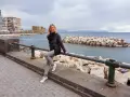 Donna sorridente si gode il panorama di Castel dell'Ovo e del mare, un assaggio di Napoli in 3 giorni.