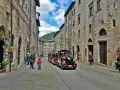 Treno turistico attraversa una strada acciottolata di Gubbio, un'idea per cosa vedere a Gubbio in un giorno.