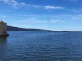 Mulino a Orbetello, un'icona da vedere. Paesaggio lagunare con cielo azzurro e colline sullo sfondo.