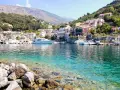 Un borgo colorato su una collina, con barche e yacht in un mare cristallino. Un esempio di posti belli da visitare in Italia a poco prezzo.