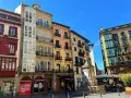 Edifici colorati con balconi in ferro battuto e una fontana in una piazza. Perfetto per scoprire cosa vedere a Bilbao in 3 giorni.