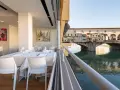 Tavoli apparecchiati in un ristorante con vista su Ponte Vecchio. Un'ottima opzione per sapere dove mangiare a Firenze.