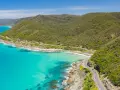 La Great Ocean Road, un must per chi cerca cosa vedere in Australia, serpeggia tra montagne verdi e acque turchesi.