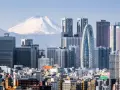 Skyline di grattacieli moderni con il Monte Fuji innevato sullo sfondo, un panorama iconico della citta piu popolata al mondo.