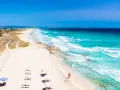 Spiaggia da sogno in Spagna dove andare al mare: sabbia bianca, acque turchesi e un sentiero tra le dune.