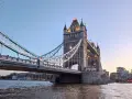 La Tower Bridge illuminata, un'icona per chi ama viaggiare a Londra, si specchia sul Tamigi al tramonto.