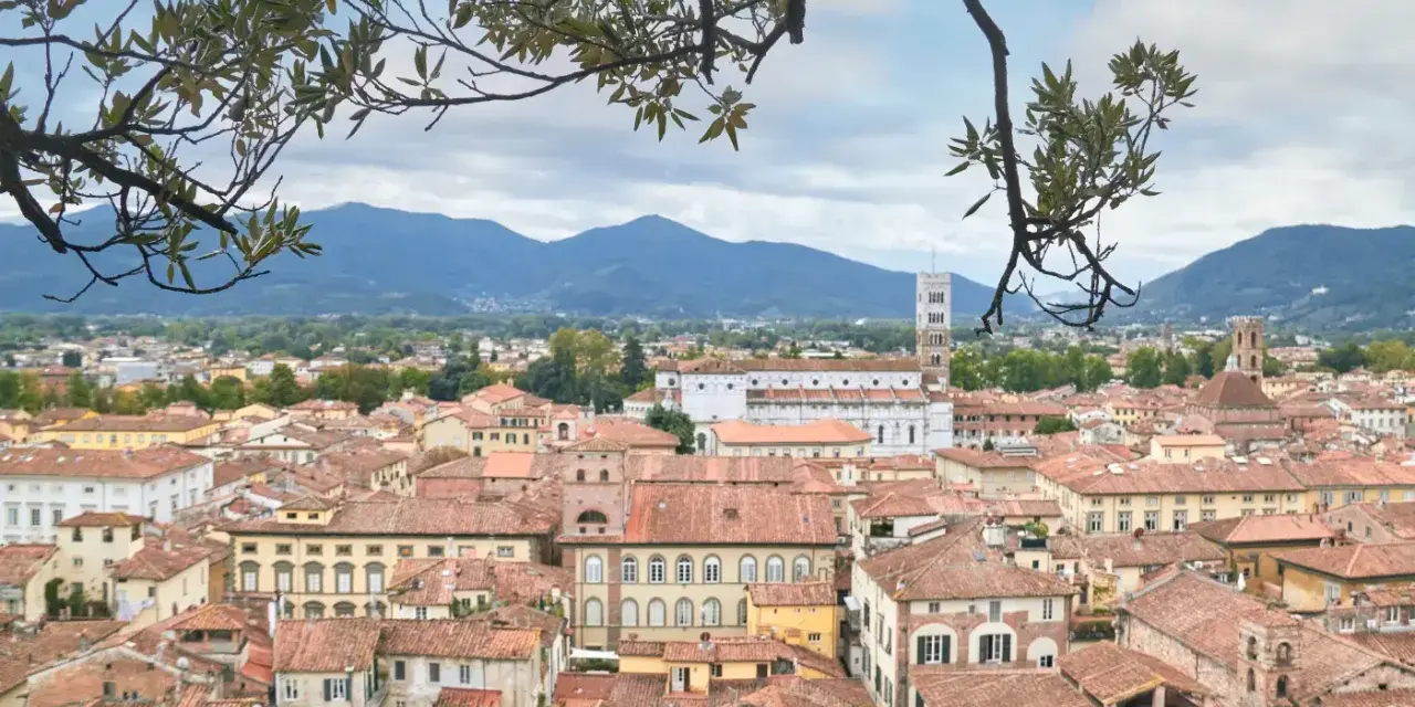 Panoramica di Lucca con tetti rossi e montagne sullo sfondo. Perfetto per scoprire cosa vedere in un giorno.