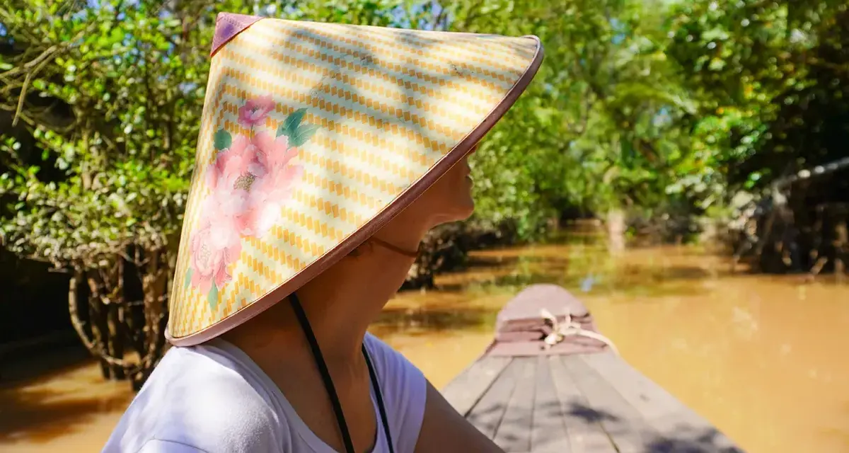 Giro in barca tra i canali del Vietnam, con un cappello tradizionale. Un'esperienza da non perdere tra le cose da fare a Vietnam.