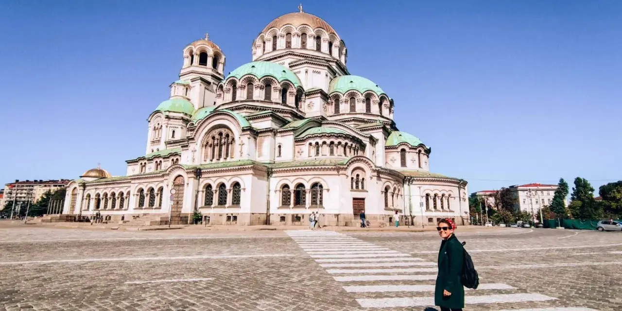 Una donna attraversa la strada davanti alla maestosa Cattedrale Alexander Nevsky, un'icona di cosa fare a Sofia.