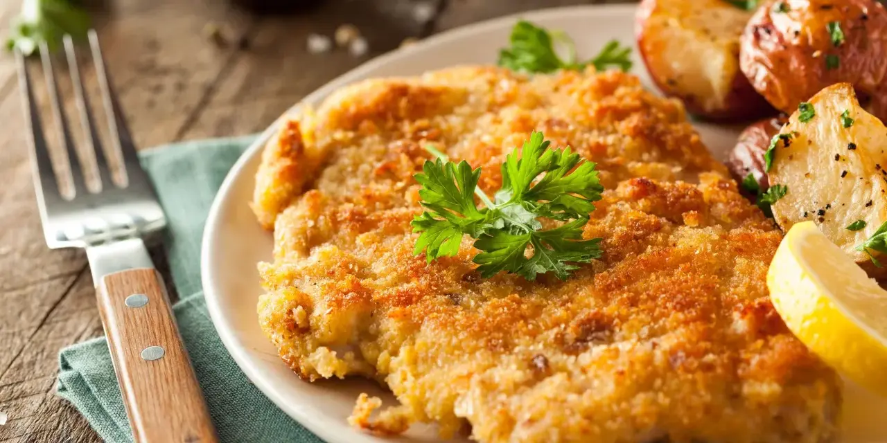 Wiener Schnitzel con patate arrosto e limone: un classico da provare per scoprire cosa mangiare a Vienna.