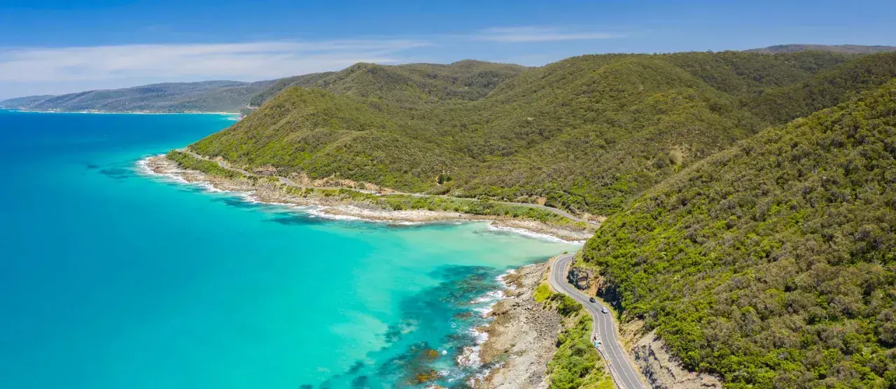 La Great Ocean Road, un must per chi cerca cosa vedere in Australia, serpeggia tra montagne verdi e acque turchesi.