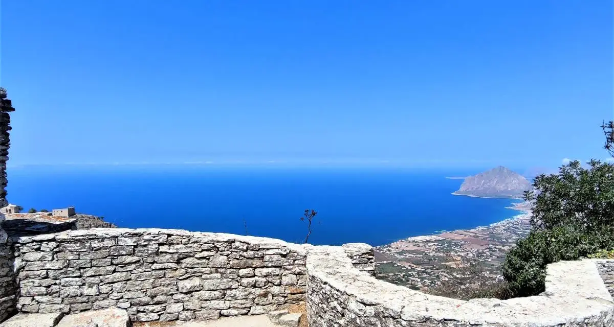 Vista mozzafiato dal castello di Erice, con il mare blu intenso e il Monte Cofano all'orizzonte. Un luogo magico da esplorare.
