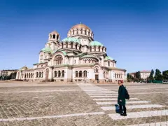 Una donna attraversa la strada davanti alla maestosa Cattedrale Alexander Nevsky, un'icona di cosa fare a Sofia.