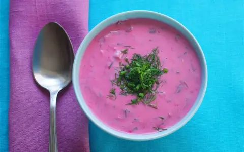Zuppa fredda di barbabietole, un classico di cosa si mangia in Polonia, guarnita con aneto e erba cipollina.