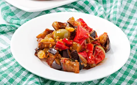 Caponata, uno dei piatti tipici della Sicilia, con melanzane, peperoni, olive e pomodoro.