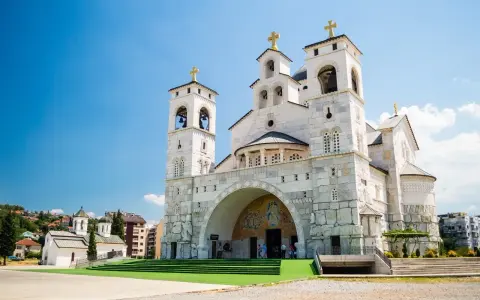 La Cattedrale della Resurrezione di Cristo a Podgorica, cosa vedere: imponente architettura ortodossa con torri campanarie e croci dorate sotto un cielo azzurro.