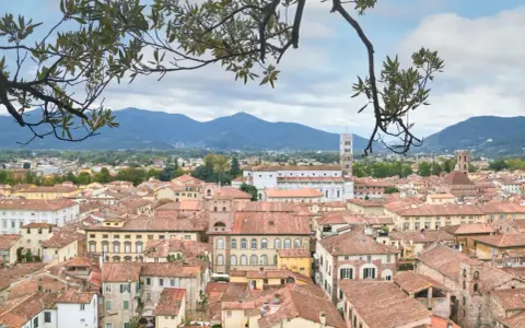 Panoramica di Lucca con tetti rossi e montagne sullo sfondo. Perfetto per scoprire cosa vedere in un giorno.