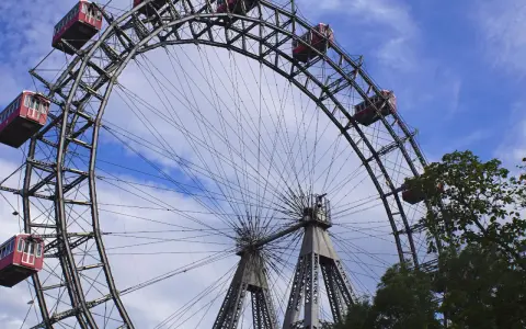 La Ruota Panoramica di Vienna, un'icona per chi cerca cosa vedere a Vienna in 1 giorno, con le sue cabine rosse sotto un cielo azzurro.