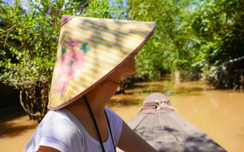 Giro in barca tra i canali del Vietnam, con un cappello tradizionale. Un'esperienza da non perdere tra le cose da fare a Vietnam.