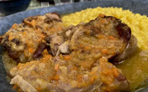 Un piatto di ossobuco con risotto alla milanese, un classico da provare per scoprire cosa mangiare a Milano.