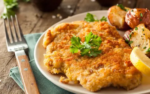 Wiener Schnitzel con patate arrosto e limone: un classico da provare per scoprire cosa mangiare a Vienna.