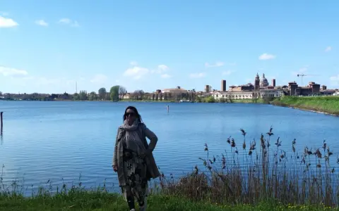 Donna con sciarpa e cappotto ammira il panorama di Mantova, un luogo incantevole da esplorare.