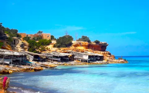 Scogliere rocciose e case di pescatori a Formentera. Un luogo ideale per scoprire le cose da fare a Formentera, tra cui godersi il mare cristallino.