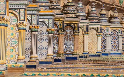 Ornate tiled columns and arches in Seville, Spain.