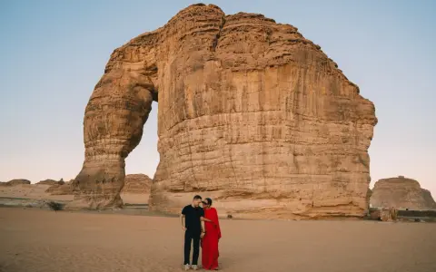 Coppia romantica davanti alla Roccia Elefante, una delle meraviglie naturali da vedere in Arabia Saudita.