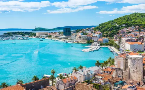 Splendido panorama di Spalato: cosa vedere nel porto turistico, la città con i suoi edifici storici e la collina verdeggiante.