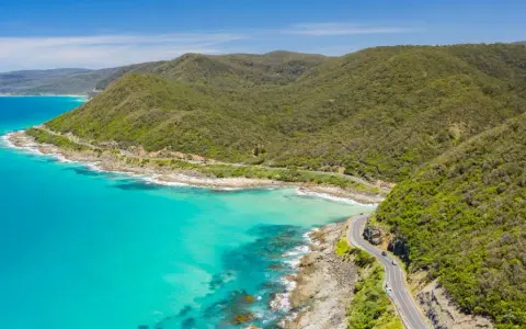 La Great Ocean Road, un must per chi cerca cosa vedere in Australia, serpeggia tra montagne verdi e acque turchesi.
