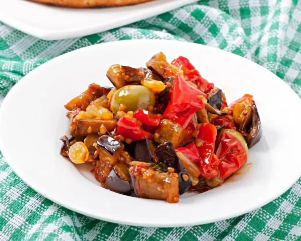 Caponata, uno dei piatti tipici della Sicilia, con melanzane, peperoni, olive e pomodoro.