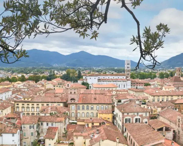 Panoramica di Lucca con tetti rossi e montagne sullo sfondo. Perfetto per scoprire cosa vedere in un giorno.