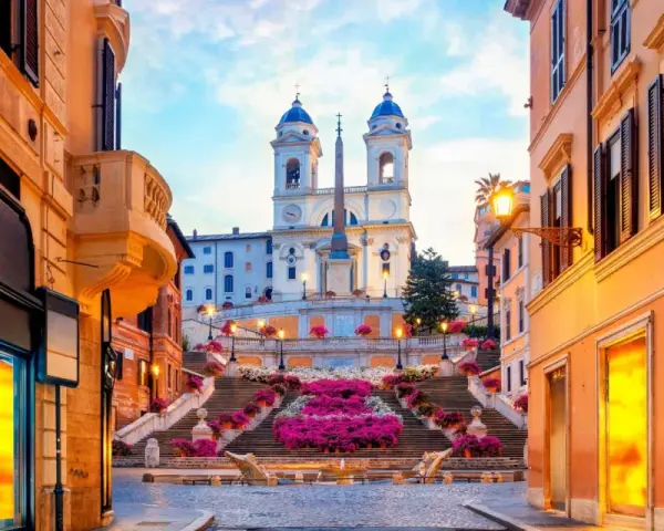 Scalinata di Trinità dei Monti a Roma, un luogo iconico per i tuoi prossimi viaggi da fare, con fiori colorati e un'atmosfera magica.