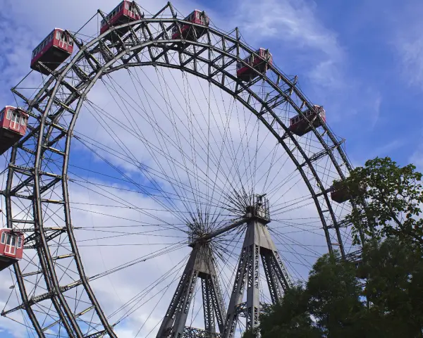 La Ruota Panoramica di Vienna, un'icona per chi cerca cosa vedere a Vienna in 1 giorno, con le sue cabine rosse sotto un cielo azzurro.