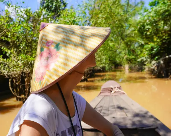 Giro in barca tra i canali del Vietnam, con un cappello tradizionale. Un'esperienza da non perdere tra le cose da fare a Vietnam.