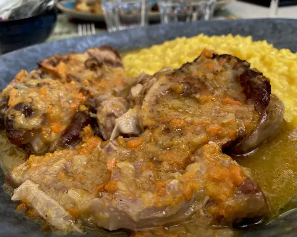 Un piatto di ossobuco con risotto alla milanese, un classico da provare per scoprire cosa mangiare a Milano.