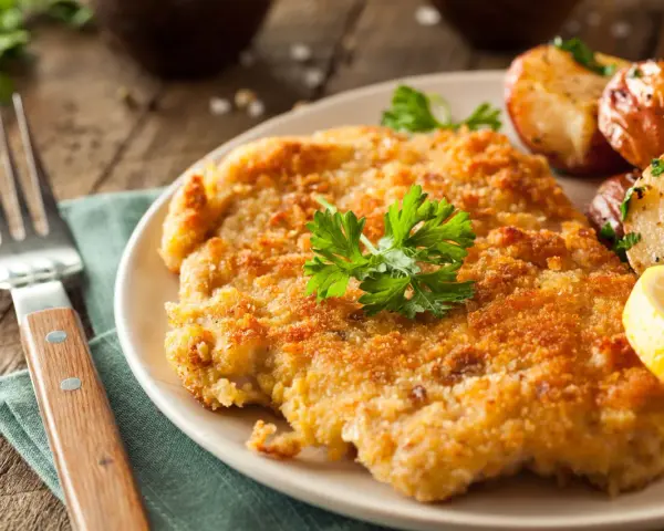 Wiener Schnitzel con patate arrosto e limone: un classico da provare per scoprire cosa mangiare a Vienna.