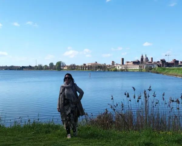 Donna con sciarpa e cappotto ammira il panorama di Mantova, un luogo incantevole da esplorare.