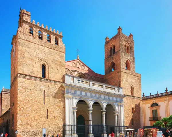 Monreale: cosa vedere? L'imponente Duomo con le sue torri campanarie domina la piazza, un capolavoro normanno da non perdere.