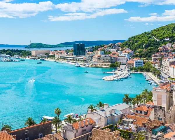 Splendido panorama di Spalato: cosa vedere nel porto turistico, la città con i suoi edifici storici e la collina verdeggiante.