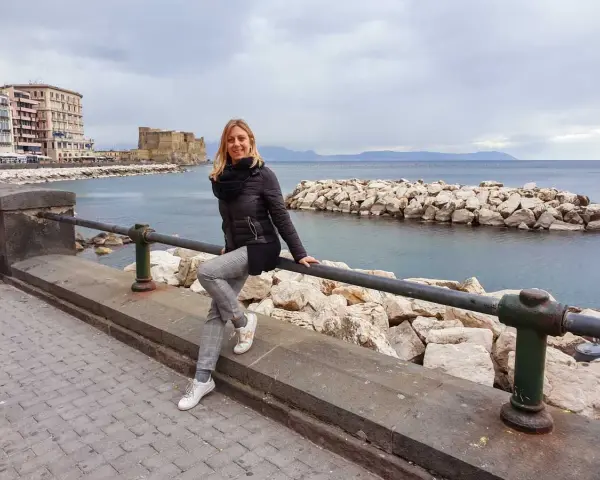 Donna sorridente si gode il panorama di Castel dell'Ovo e del mare, un assaggio di Napoli in 3 giorni.